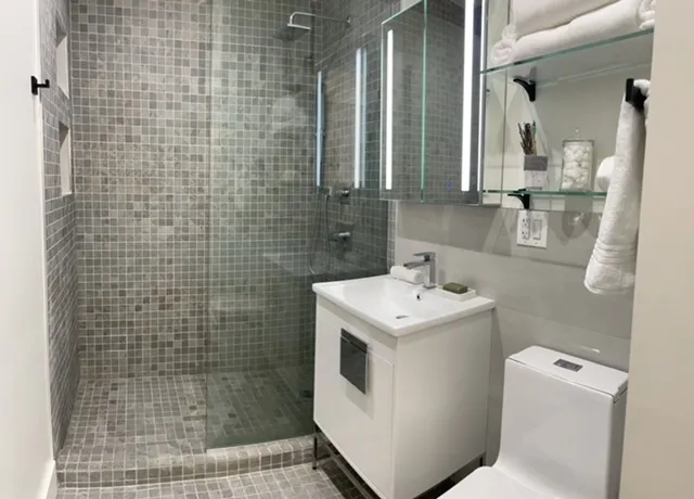a bathroom with a sink a toilet and shower