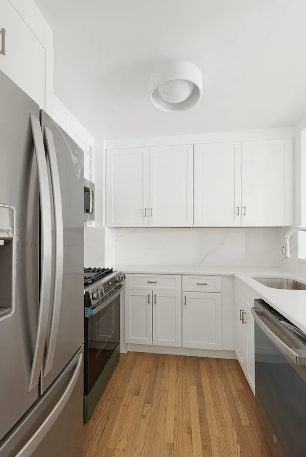 a kitchen with granite countertop a refrigerator sink and stove