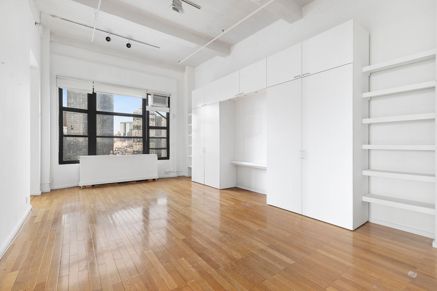 448 West 37th Street, Unit PHA Manhattan, NY 10018 - Photo 5 of 7 a view of a room with wooden floor and white walls