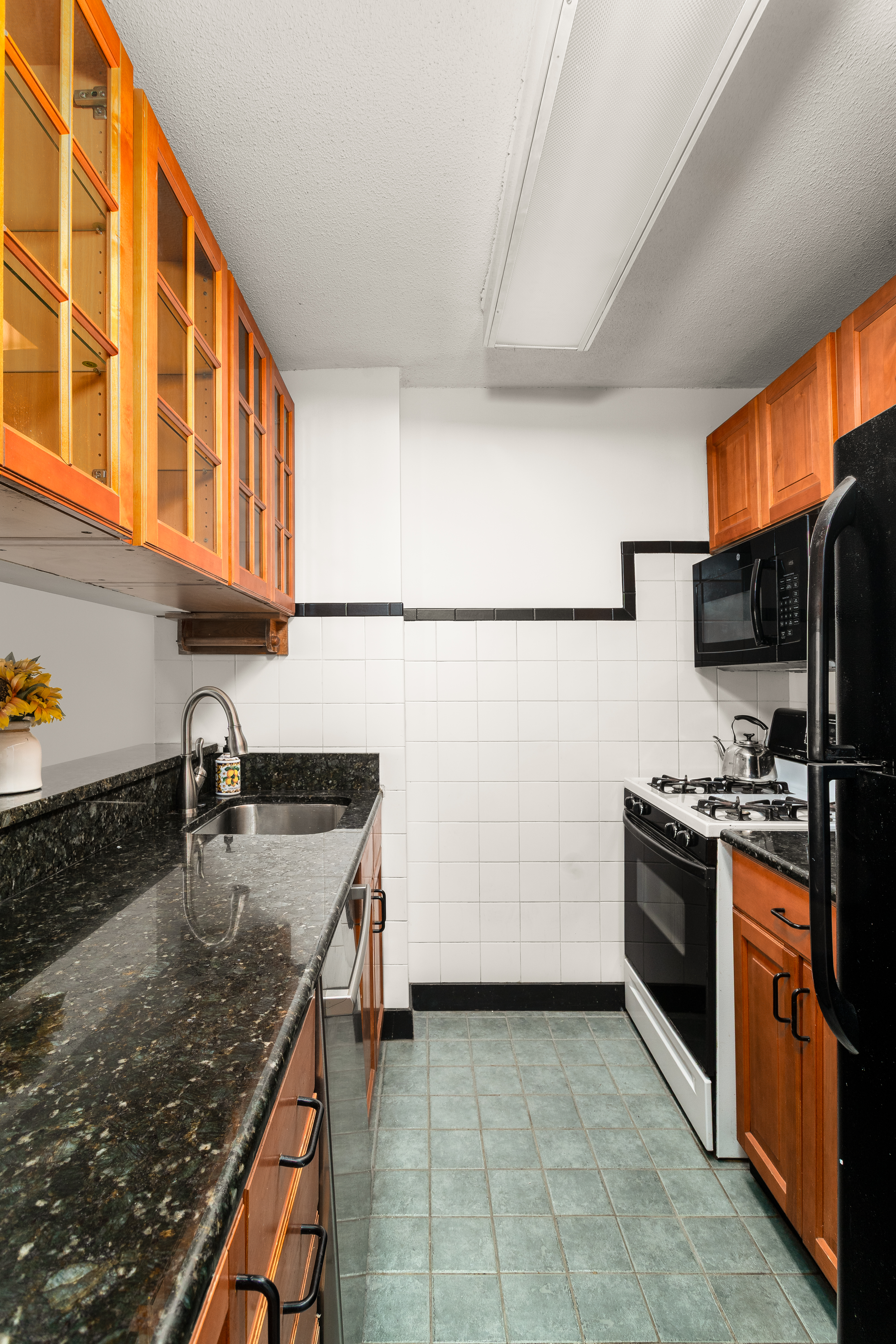 275 West 96th Street, Unit 12B Manhattan, NY 10025 - Photo 5 of 28 a kitchen with stainless steel appliances granite countertop a sink stove and refrigerator