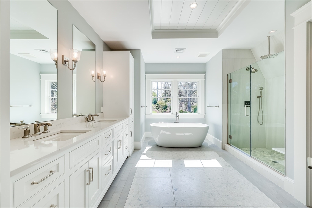 181 Dedham Street Dover, MA 02030 - Photo 7 of 19 a bathroom with a double vanity sink a large mirror and a bathtub