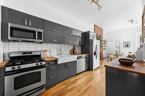 a kitchen with stainless steel appliances a stove microwave and sink