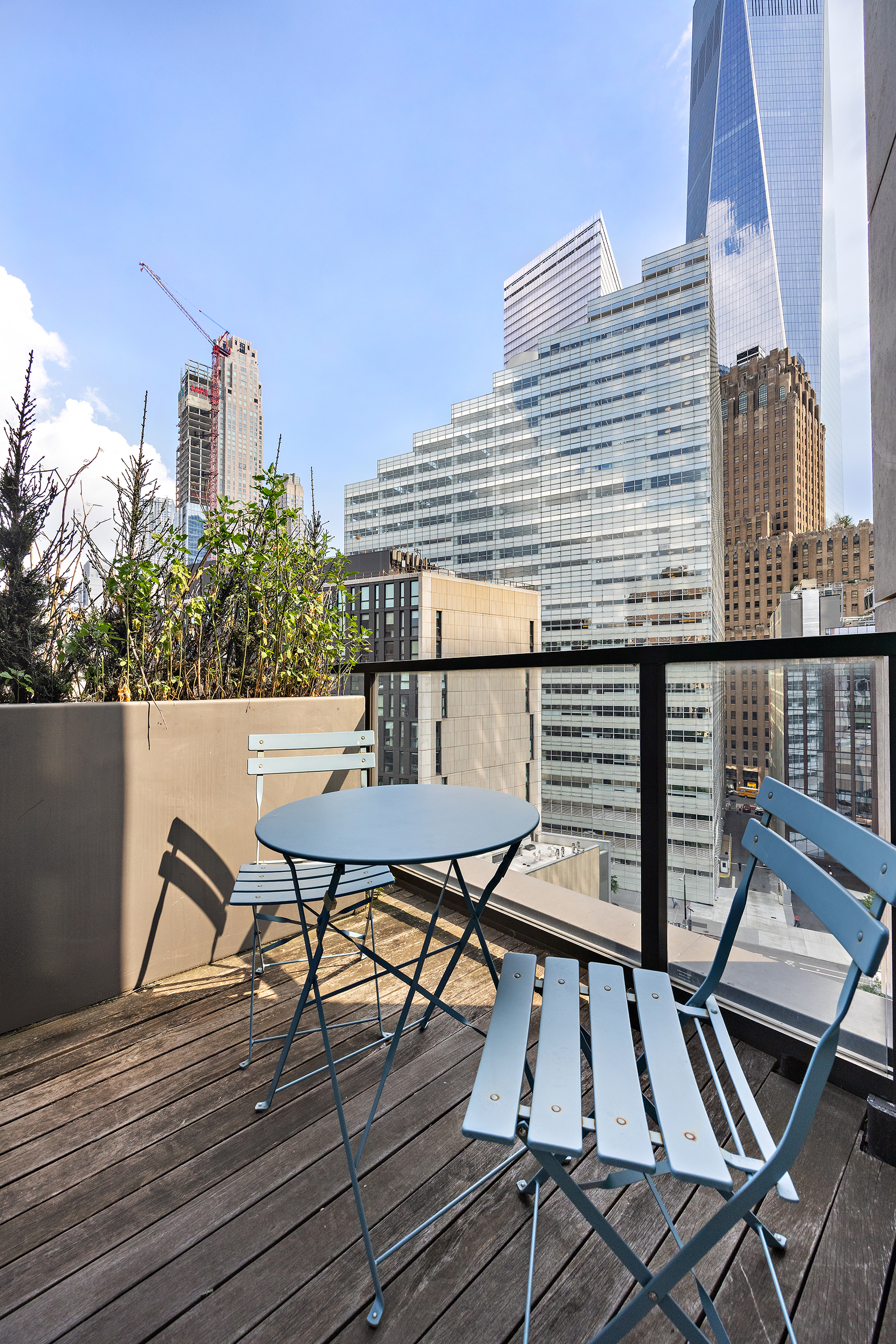 101 Warren Street, Unit 11L Manhattan, NY 10007 - Photo 19 of 28 a view of a roof deck with table and chairs a barbeque with wooden floor and fence