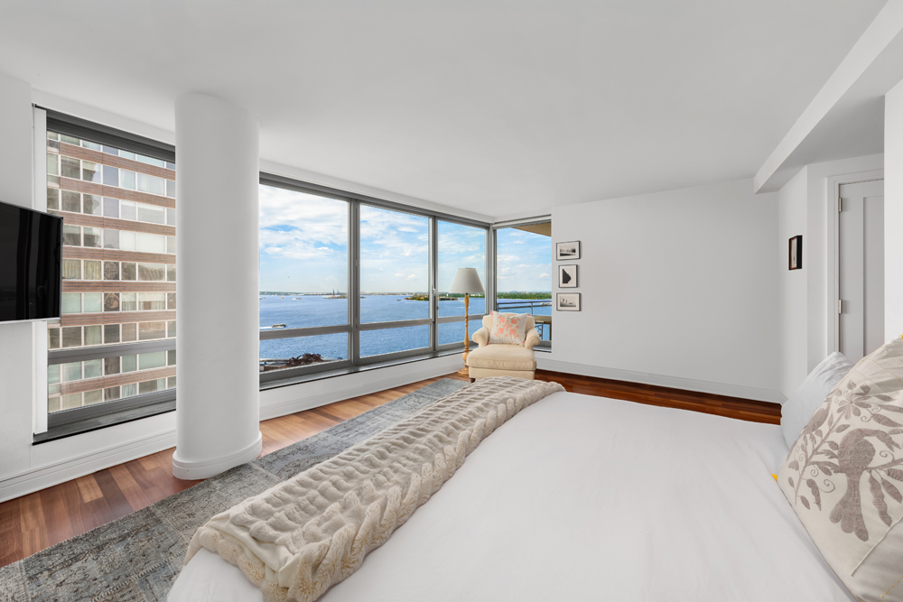 30 West Street, Unit 19F Manhattan, NY 10004 - Photo 5 of 12 a bedroom with a bed and glass door