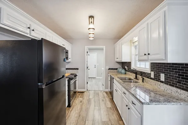 a kitchen with a refrigerator a sink and cabinets