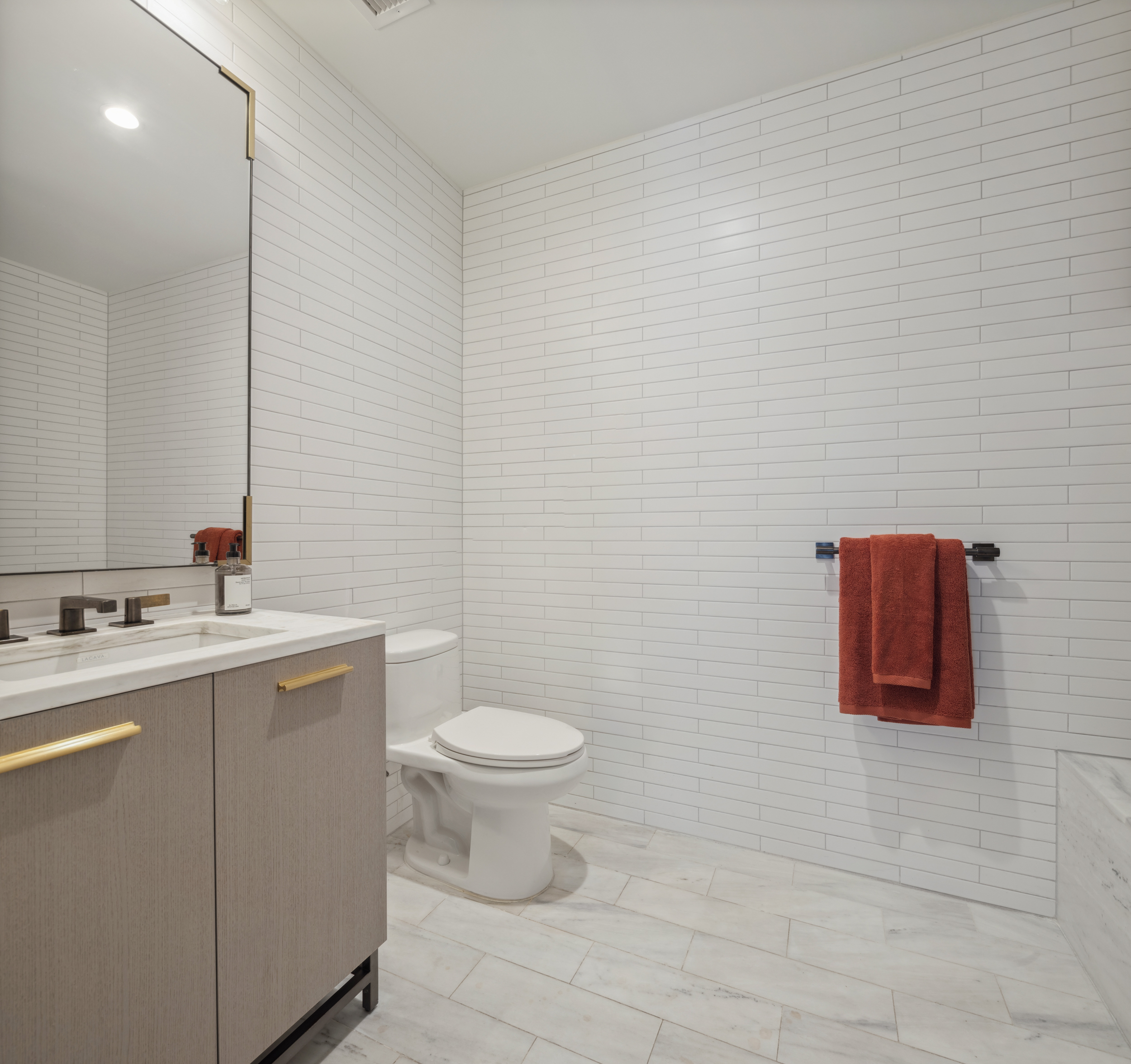 91 Leonard Street, Unit 11G Manhattan, NY 10013 - Photo 9 of 16 a bathroom with a toilet sink vanity and mirror