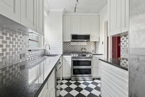 a kitchen with stainless steel appliances granite countertop a stove a sink and a microwave