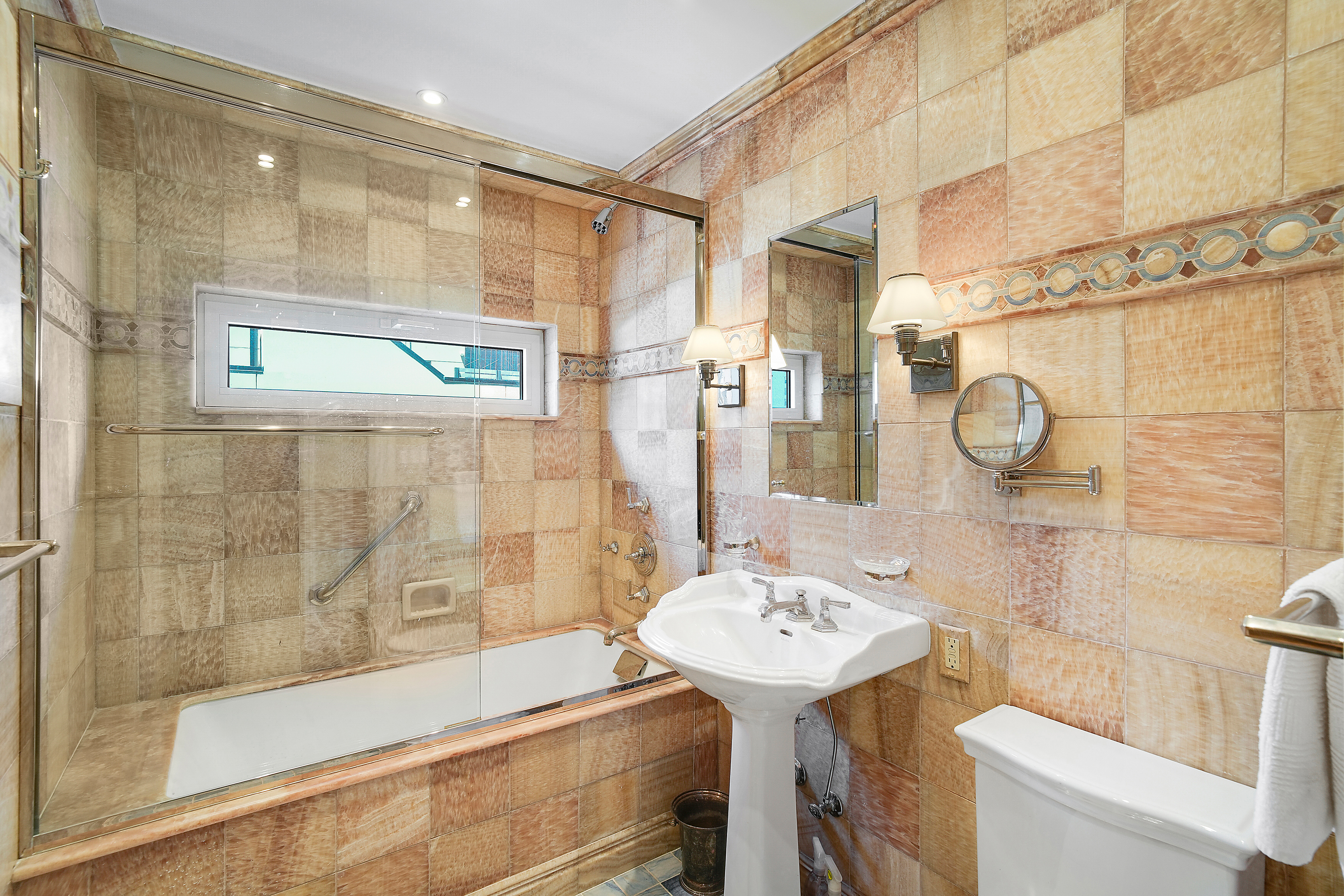 175 East 62nd Street, Unit 8D Manhattan, NY 10065 - Photo 17 of 24 a bathroom with a sink and mirror with bathtub
