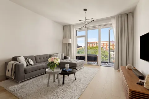 a living room with furniture a flat screen tv and a large window