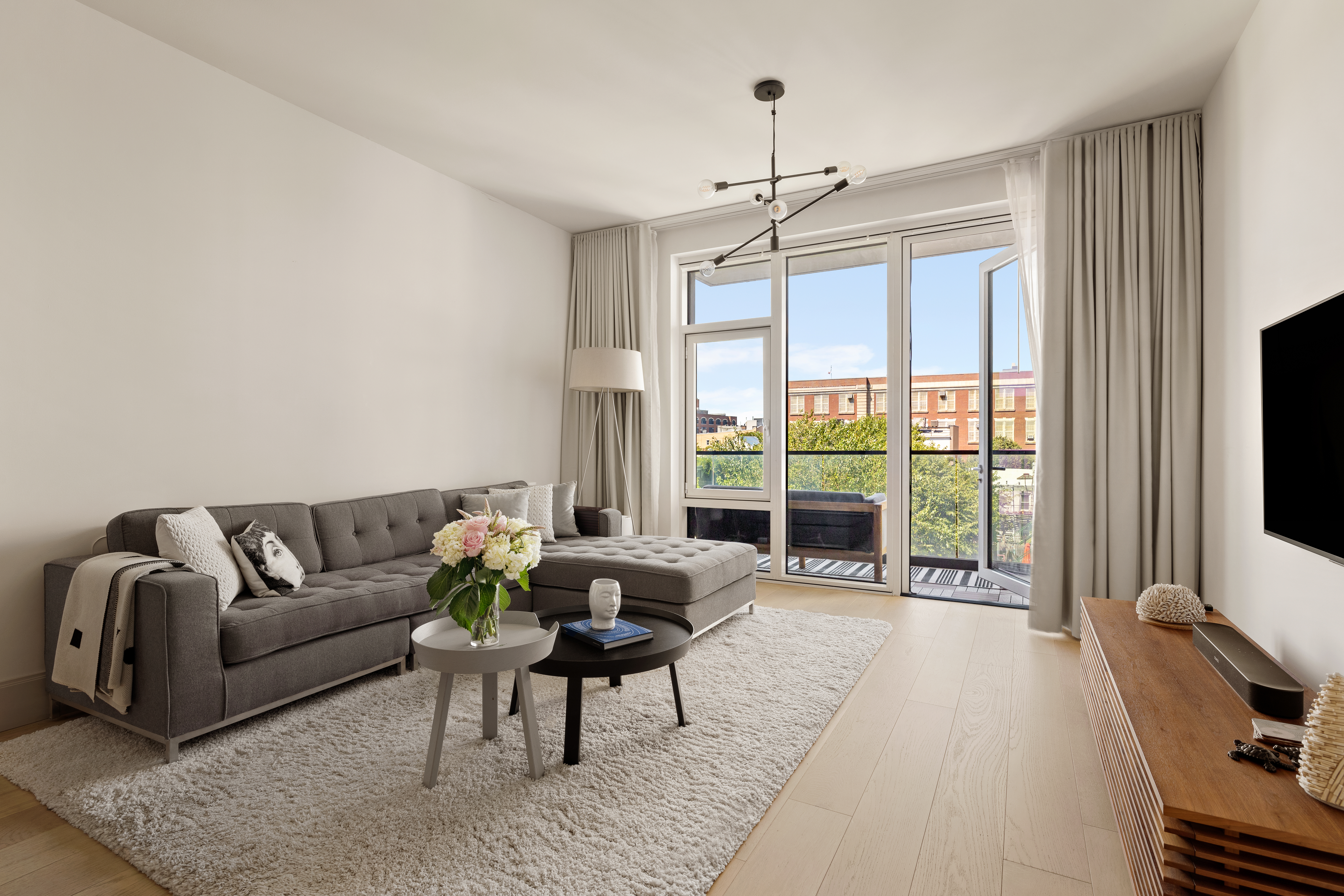 308 North 7th Street, Unit 5A Brooklyn, NY 11211 - Photo 4 of 12 a living room with furniture a flat screen tv and a large window