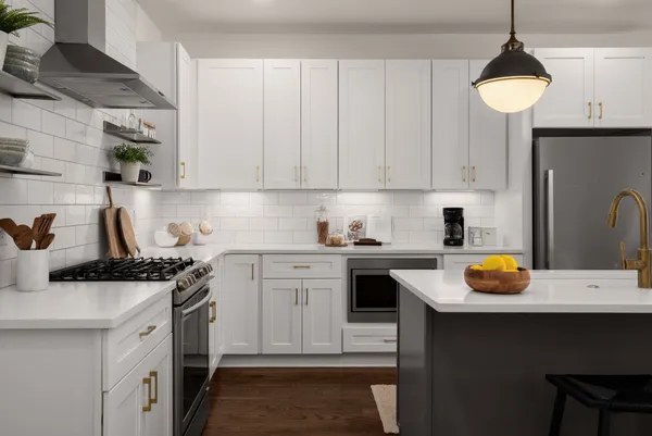 a kitchen with stainless steel appliances a stove a sink a refrigerator and cabinets