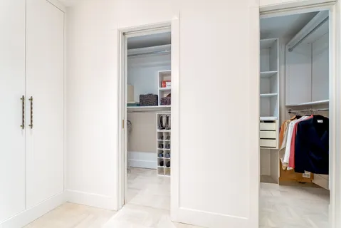 a view of walk in closet with clothes and shoes