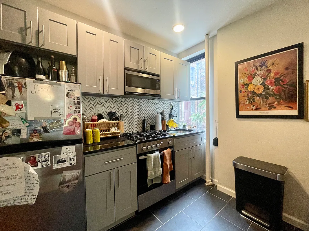 210 Thompson Street, Unit 4DN Manhattan, NY 10012 - Photo 4 of 10 a kitchen with stainless steel appliances granite countertop a stove and cabinets