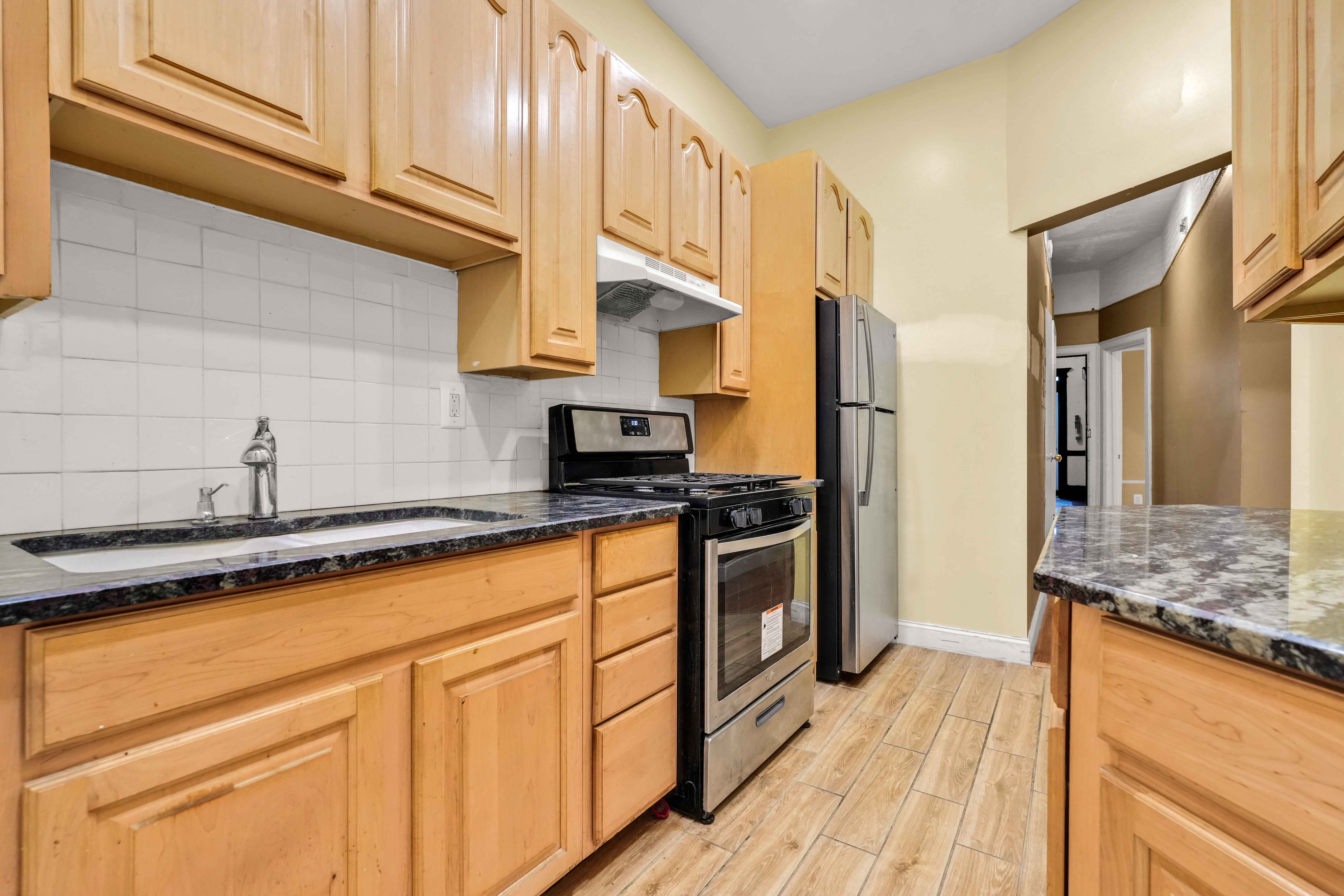 278 Lefferts Avenue Brooklyn, NY 11225 - Photo 35 of 56 a kitchen with stainless steel appliances granite countertop a sink and cabinets
