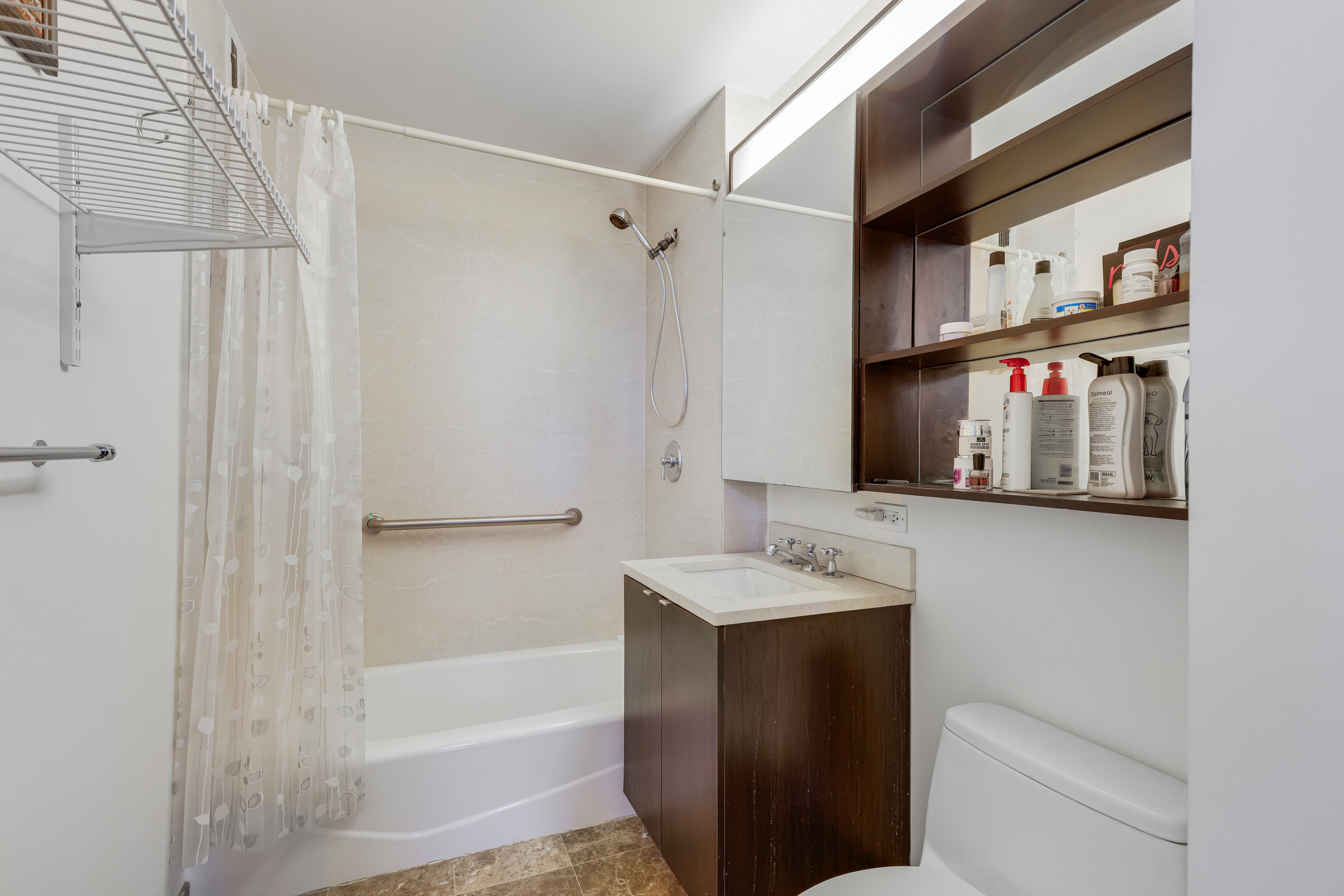 215-217 East 96th Street, Unit 25K Manhattan, NY 10128 - Photo 5 of 16 a bathroom with a sink a toilet and shower