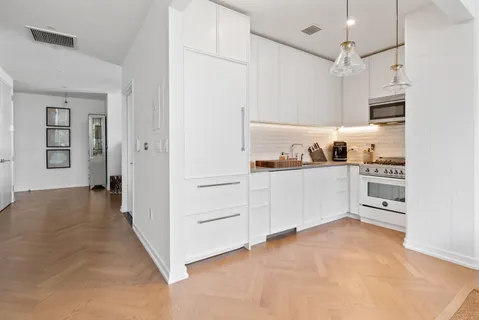 a view of a kitchen with wooden cabinets and white appliances