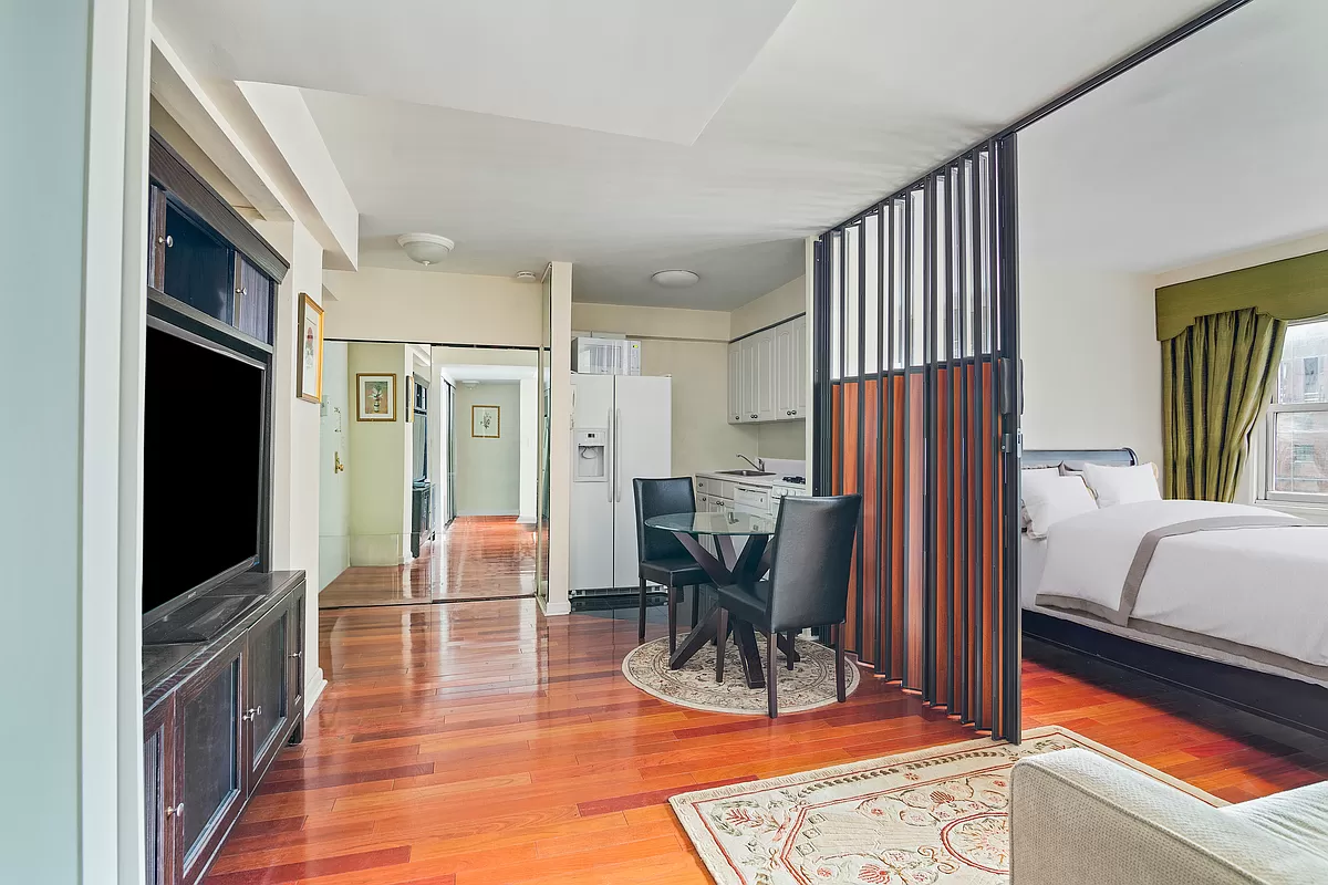 153 East 57th Street, Unit 17F Manhattan, NY 10022 - Photo 3 of 8 a view of living room filled with furniture and a flat screen tv