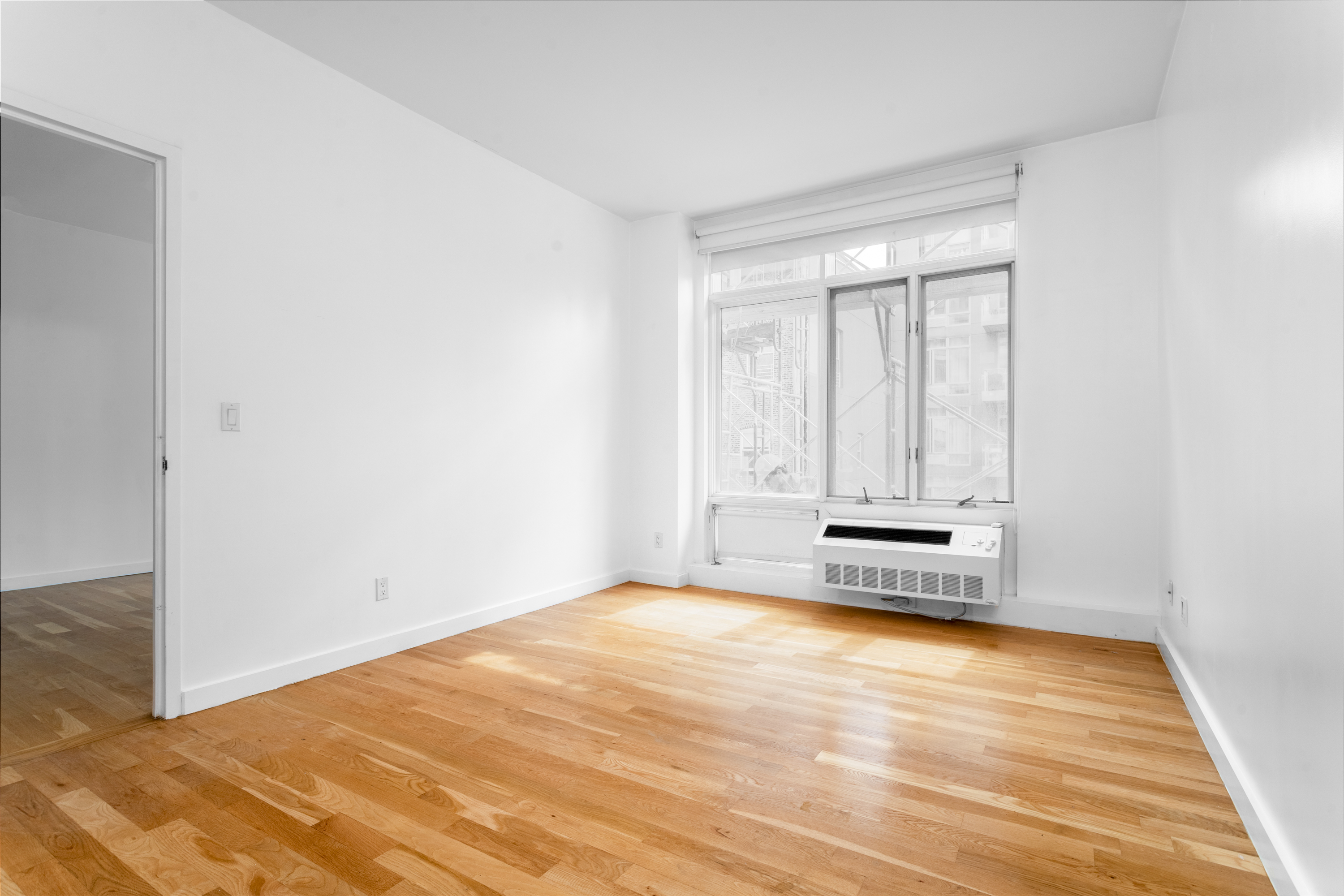 342 East 110th Street, Unit 3D Manhattan, NY 10029 - Photo 10 of 15 a view of a room with wooden floor and a window