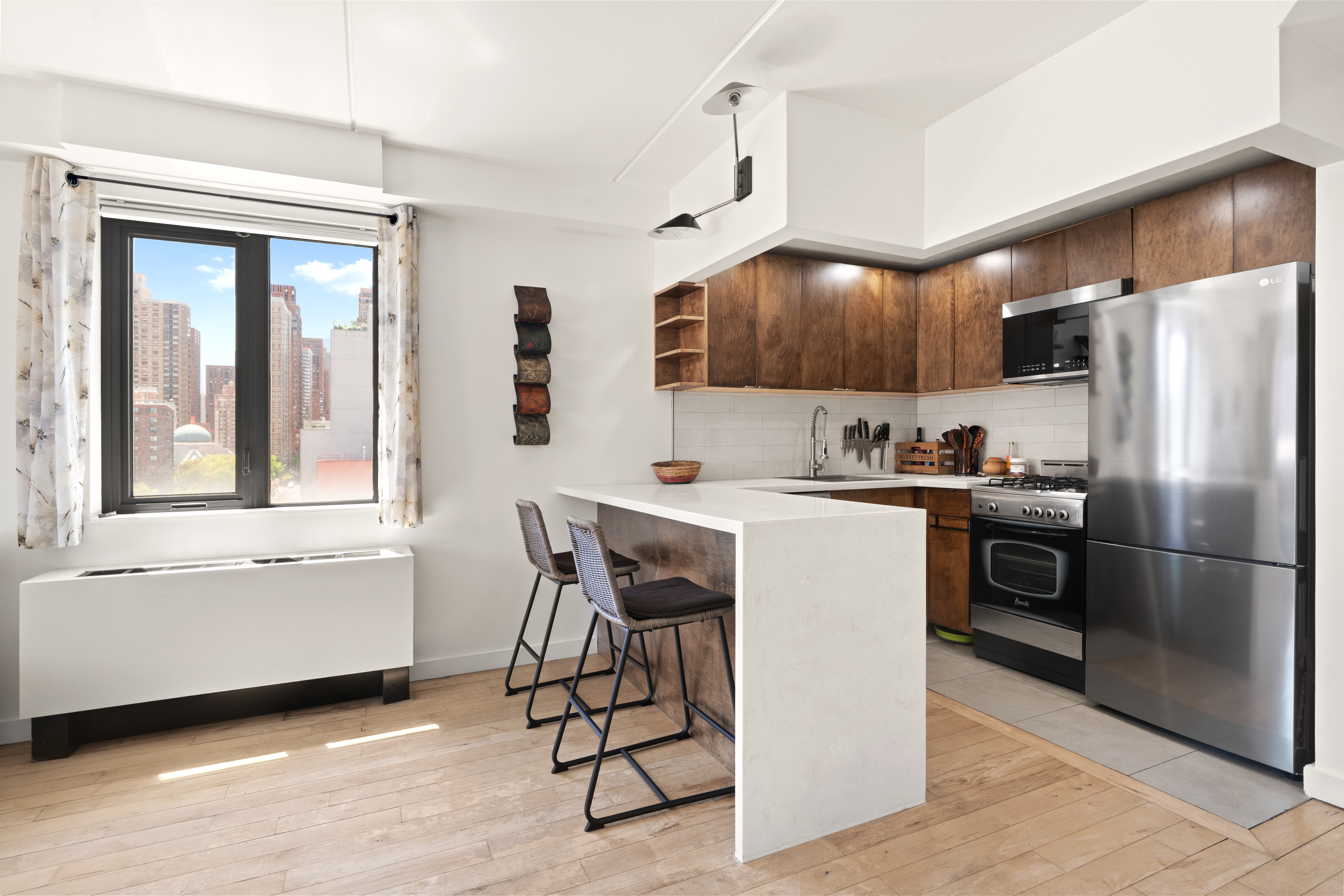 1810 3rd Avenue, Unit 9D Manhattan, NY 10029 - Photo 3 of 10 a kitchen with a refrigerator a microwave and island with wooden floor