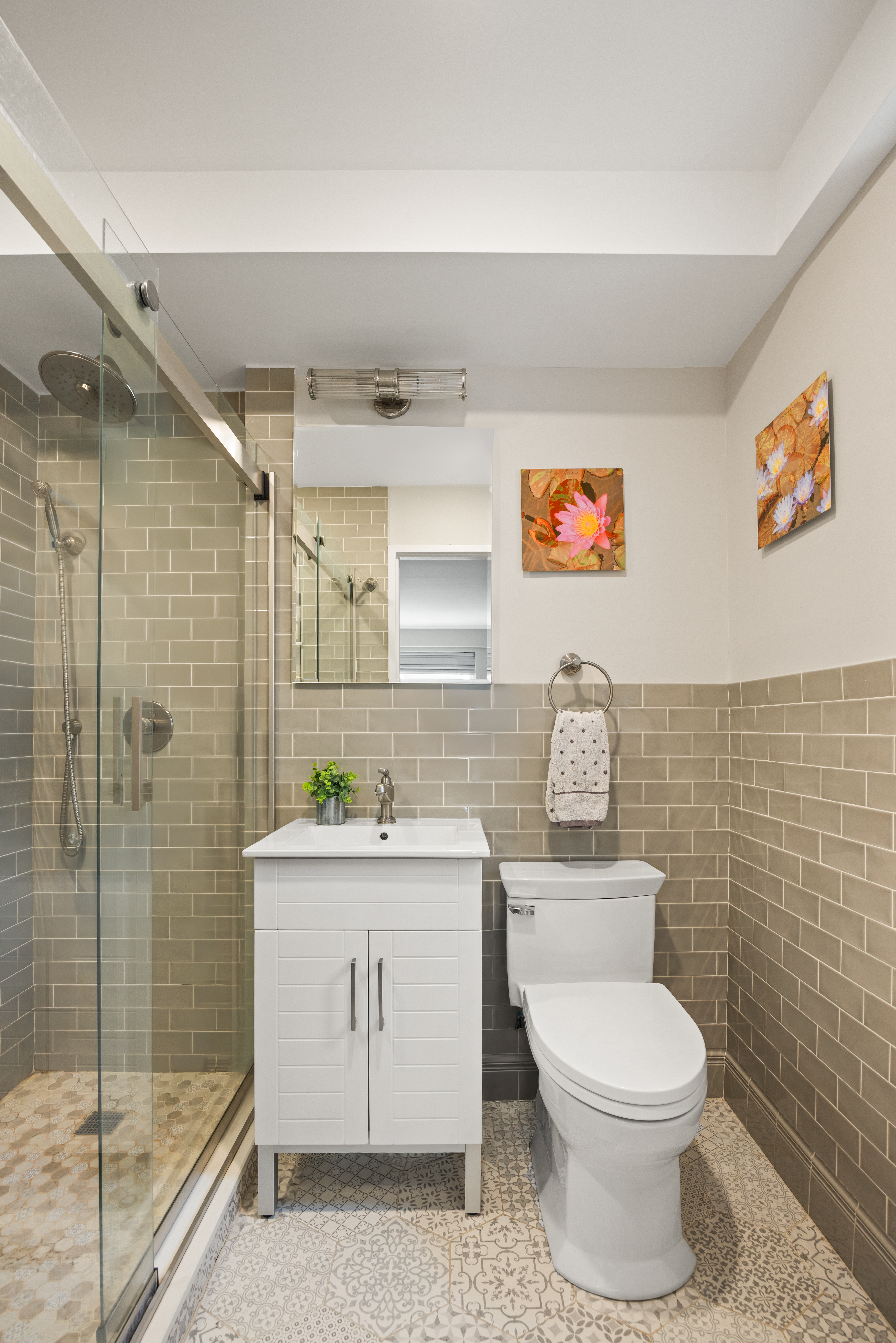 345 East 56th Street, Unit 3F Manhattan, NY 10022 - Photo 6 of 10 a bathroom with a toilet a sink and shower