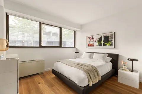 a bedroom with a bed and a large window