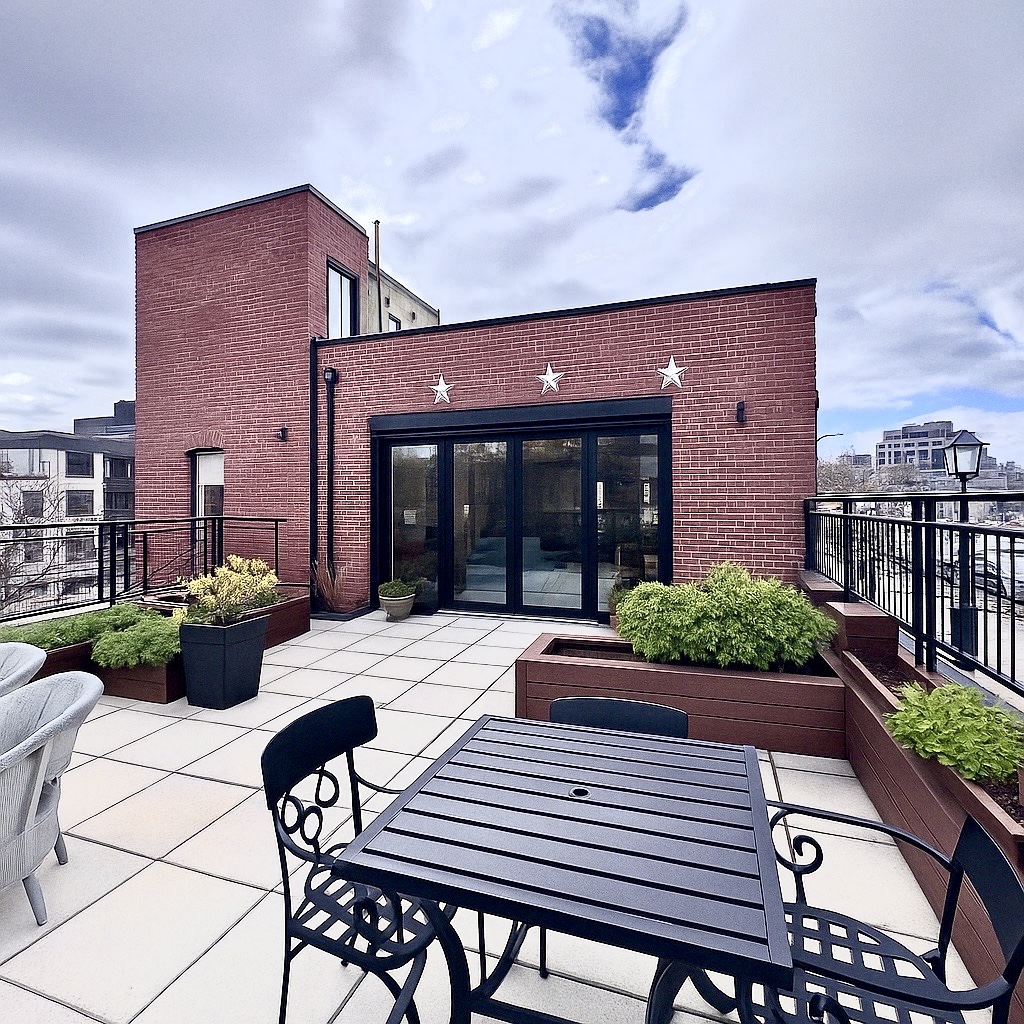 a view of a patio with table and chairs potted plants with wooden floor and fence