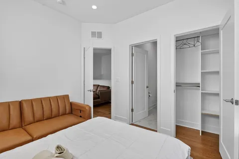 a bedroom with a bed and wooden floor