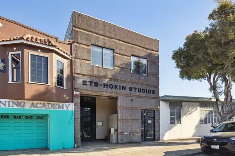 a front view of a building with a garden