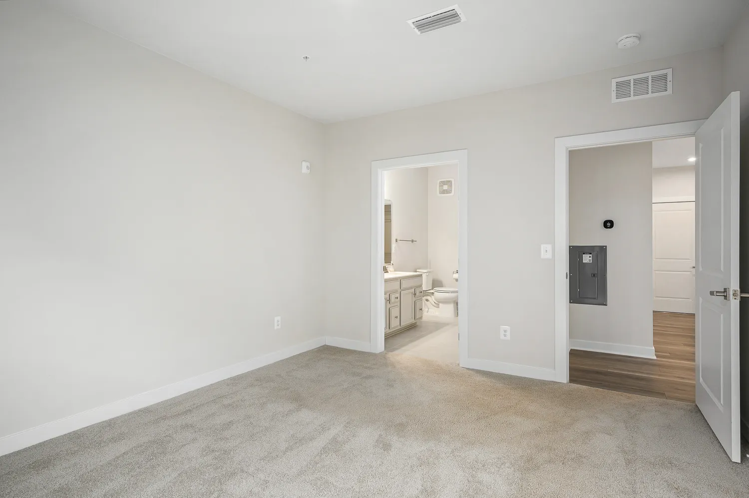 an empty room with a cabinet and mirrors