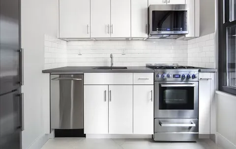 a kitchen with granite countertop a stove and a microwave