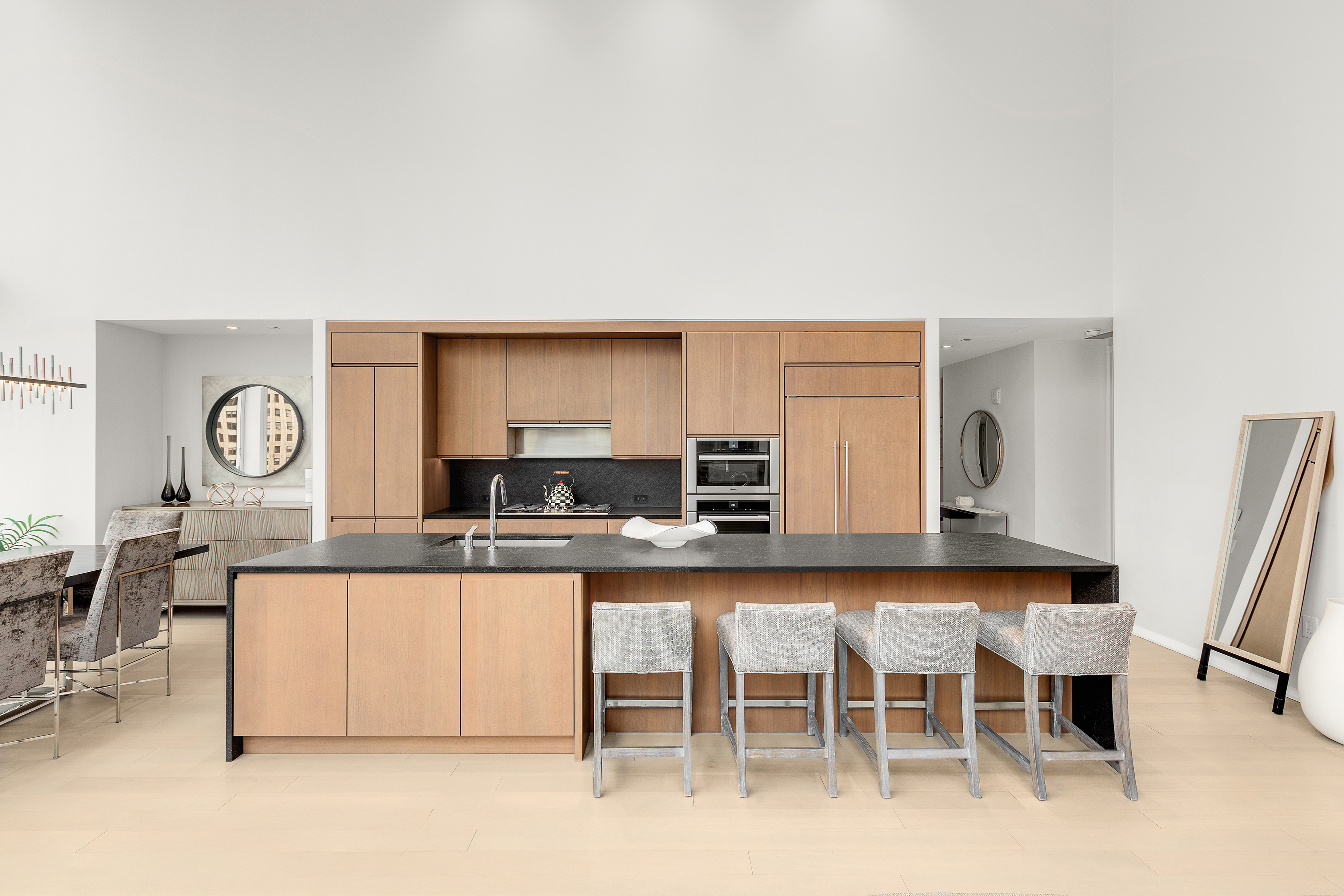 50 West Street, Unit 14B Manhattan, NY 10006 - Photo 4 of 29 a kitchen with stainless steel appliances granite countertop a stove top oven a sink a dining table and chairs