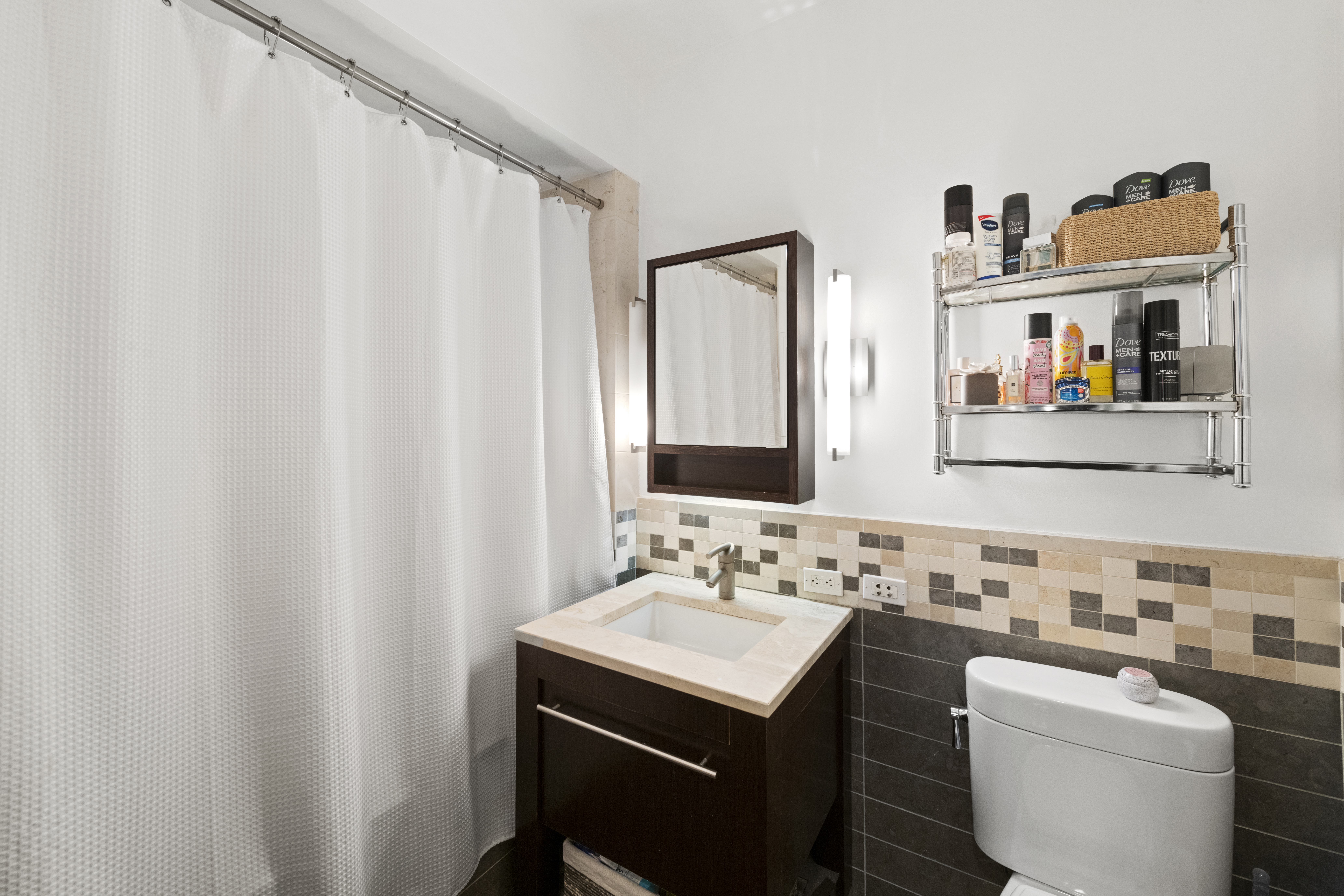 101 West 24th Street, Unit 5G Manhattan, NY 10011 - Photo 6 of 16 a bathroom with a sink a mirror and a toilet