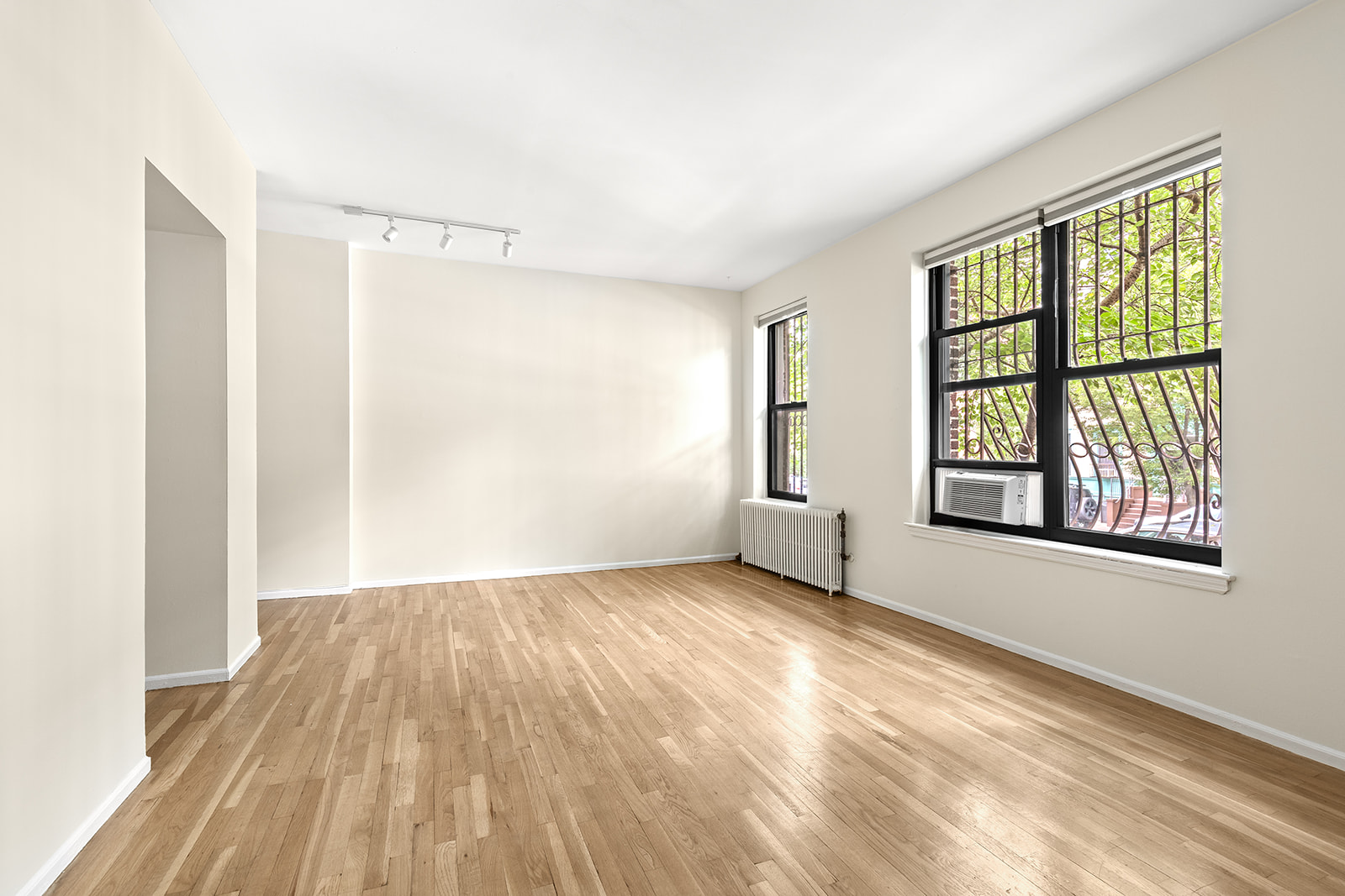 338 Prospect Place, Unit 1F Brooklyn, NY 11238 - Photo 2 of 6 a view of an empty room with a window and wooden floor