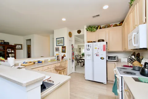 a kitchen with stainless steel appliances a stove a sink dishwasher and a refrigerator with wooden floor