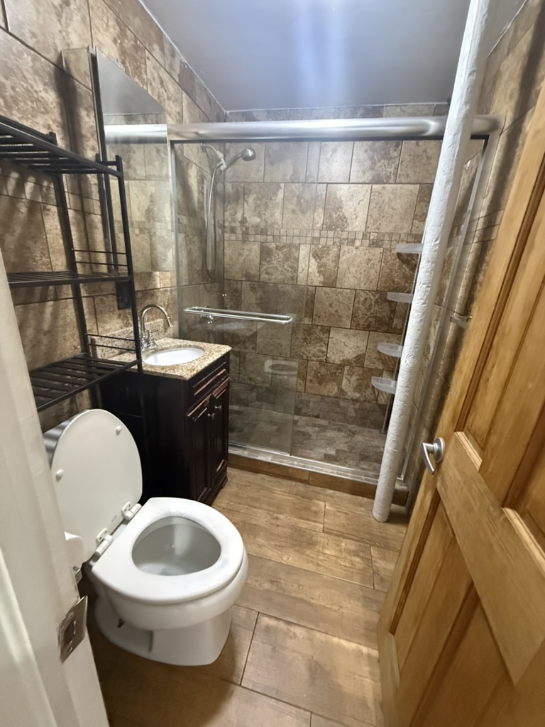 613 Marcy Avenue, Unit 1B Brooklyn, NY 11206 - Photo 6 of 8 a bathroom with a toilet a sink and a shower