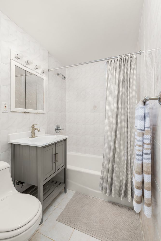 342 East 53rd Street, Unit 1G Manhattan, NY 10022 - Photo 7 of 9 a bathroom with a sink a toilet and tub