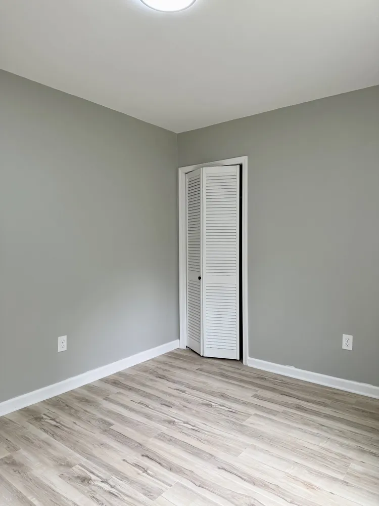 a view of empty room with wooden floor