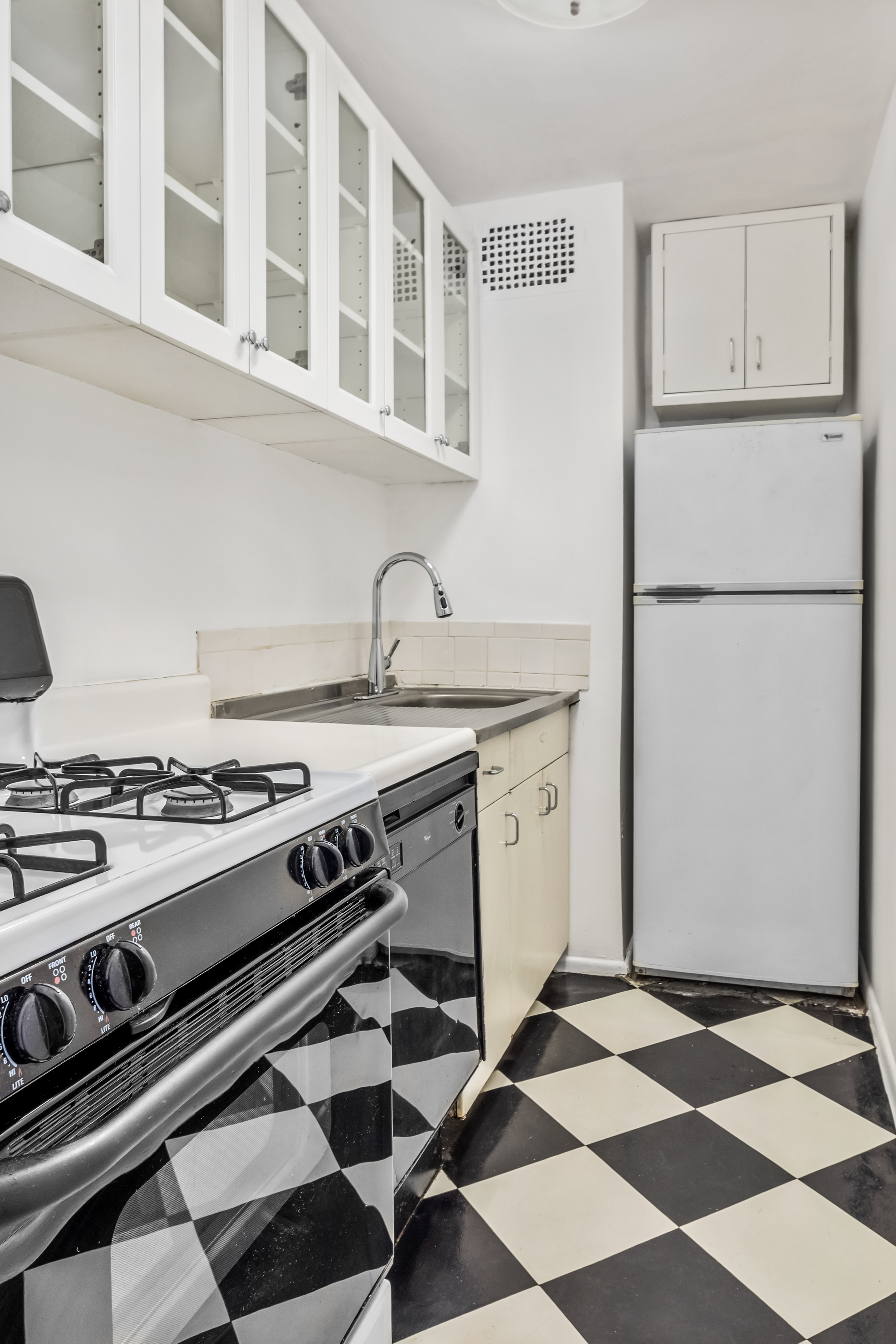 233 East 69th Street, Unit 2C Manhattan, NY 10021 - Photo 4 of 10 a kitchen with a stove a sink and a refrigerator