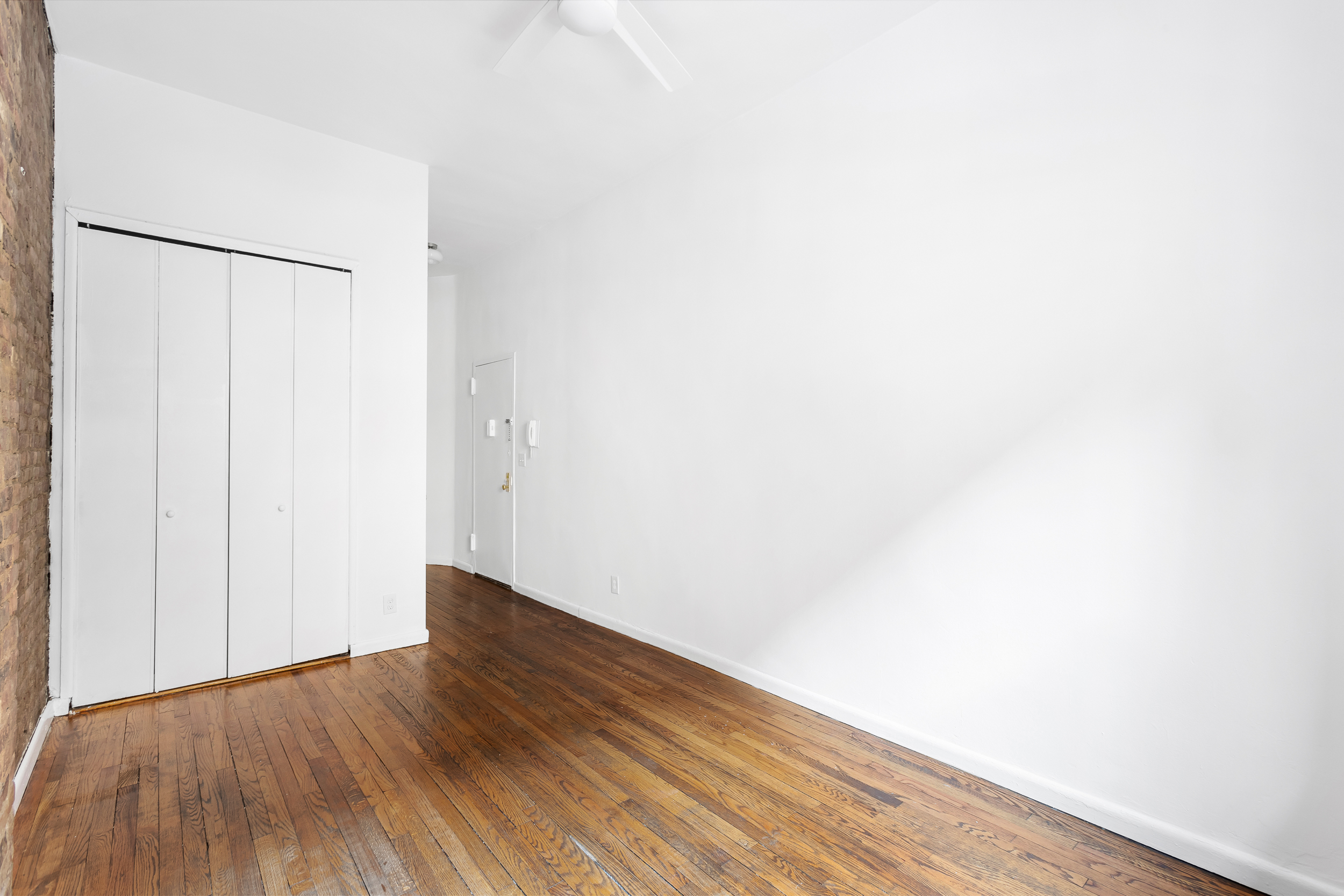 529 East 88th Street, Unit 1B Manhattan, NY 10128 - Photo 4 of 7 a view of an empty room with wooden floor