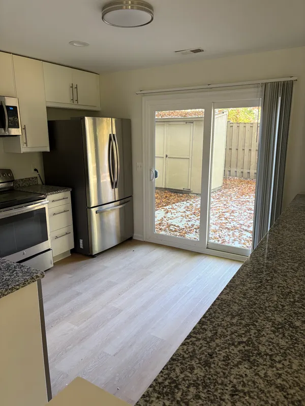 a kitchen with granite countertop a refrigerator and a stove