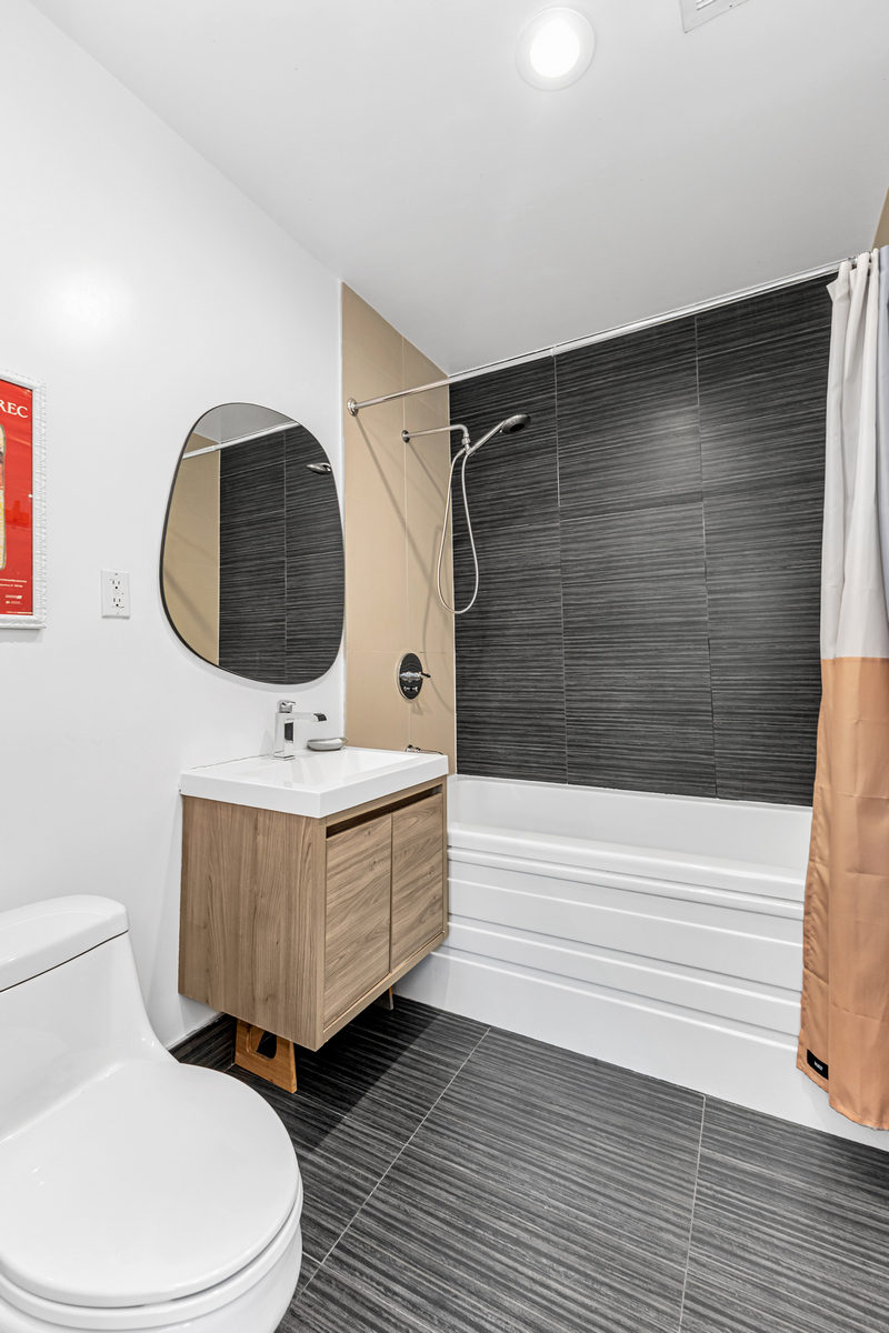 325 Greene Avenue, Unit 3B Brooklyn, NY 11238 - Photo 4 of 7 a bathroom with a toilet a sink and mirror