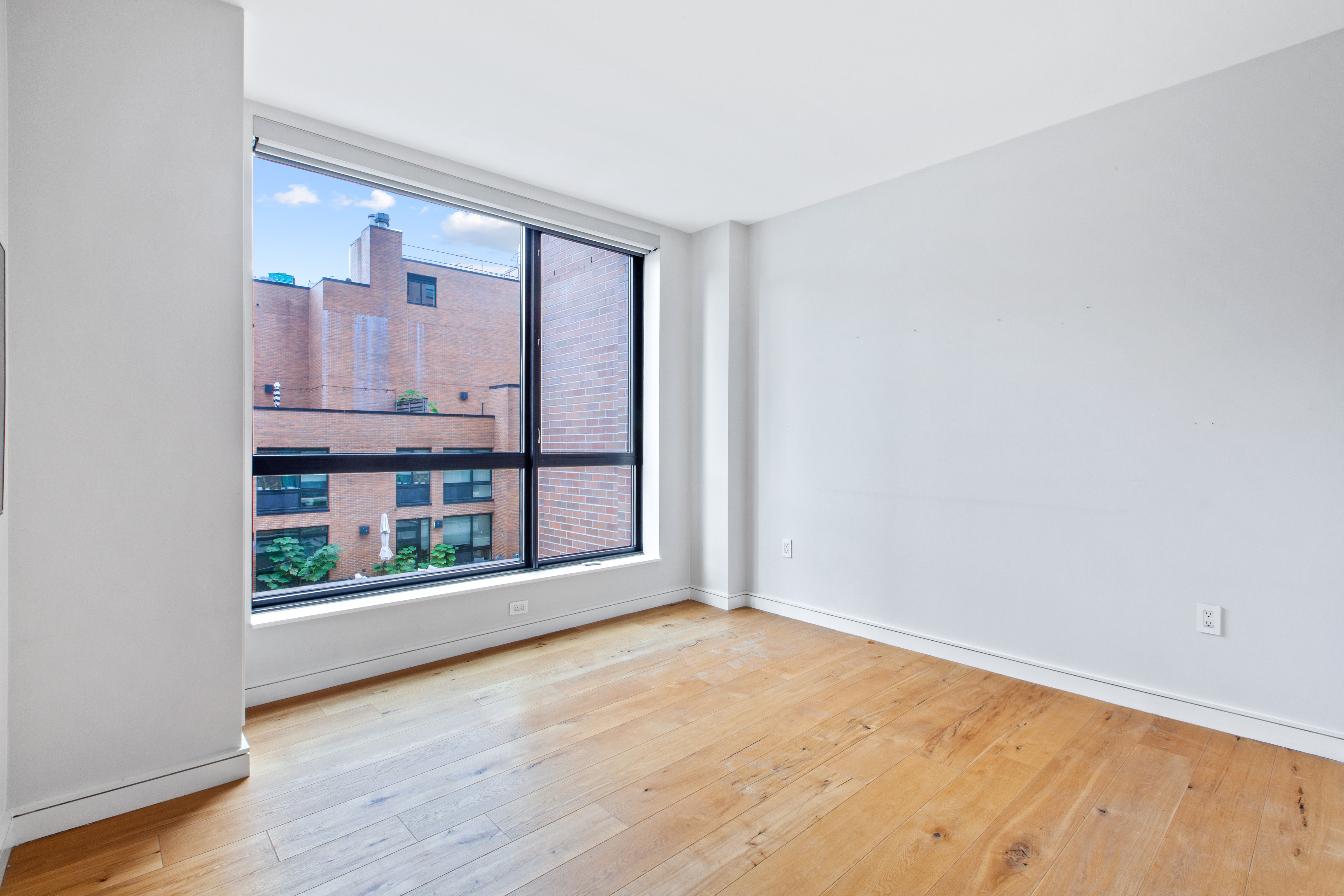 540 West 28th Street, Unit 4F Manhattan, NY 10001 - Photo 7 of 16 wooden floor in an empty room with a window