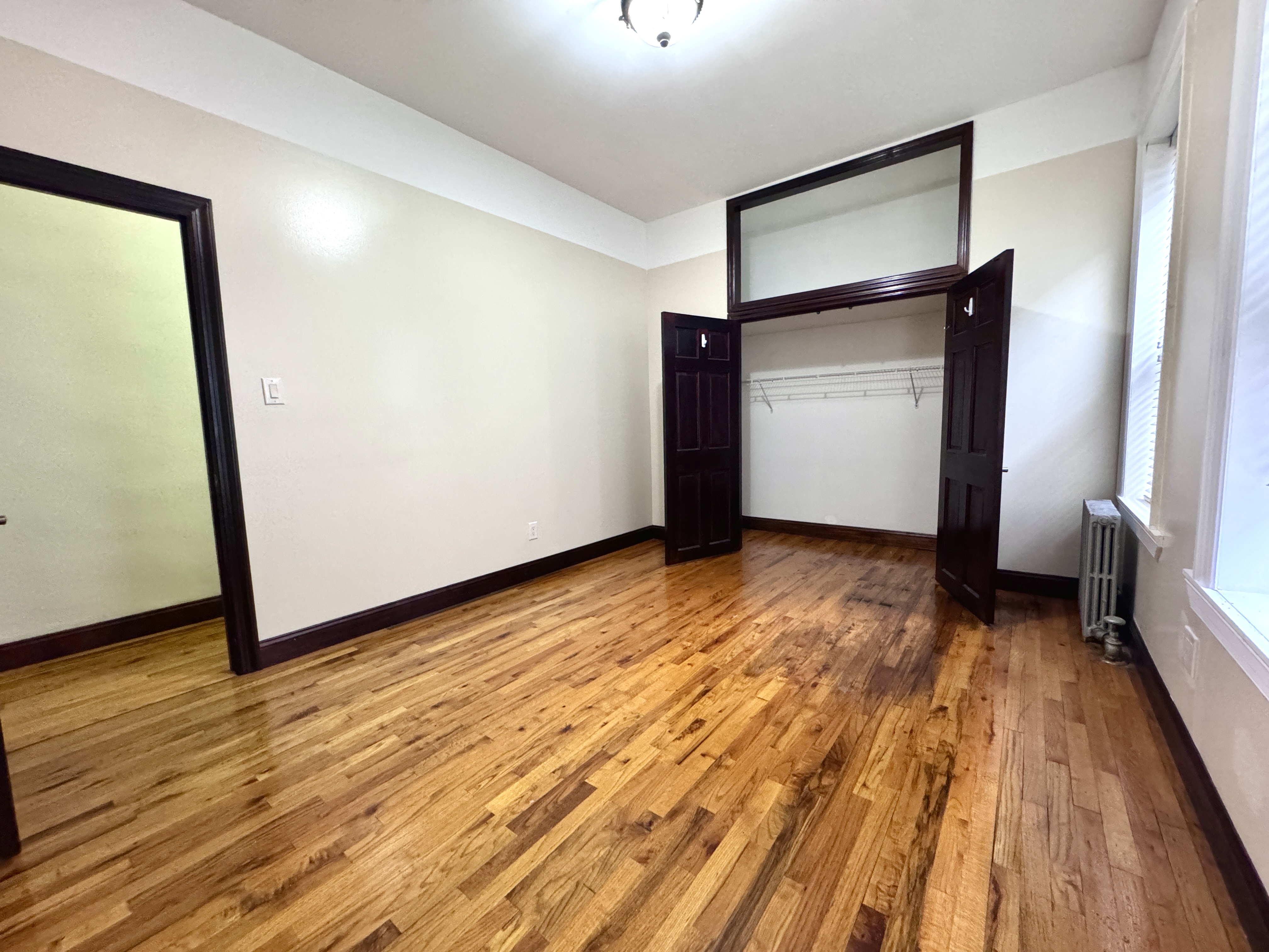 497 Park Place, Unit 4 Brooklyn, NY 11238 - Photo 5 of 14 a view of an empty room with wooden floor and a window