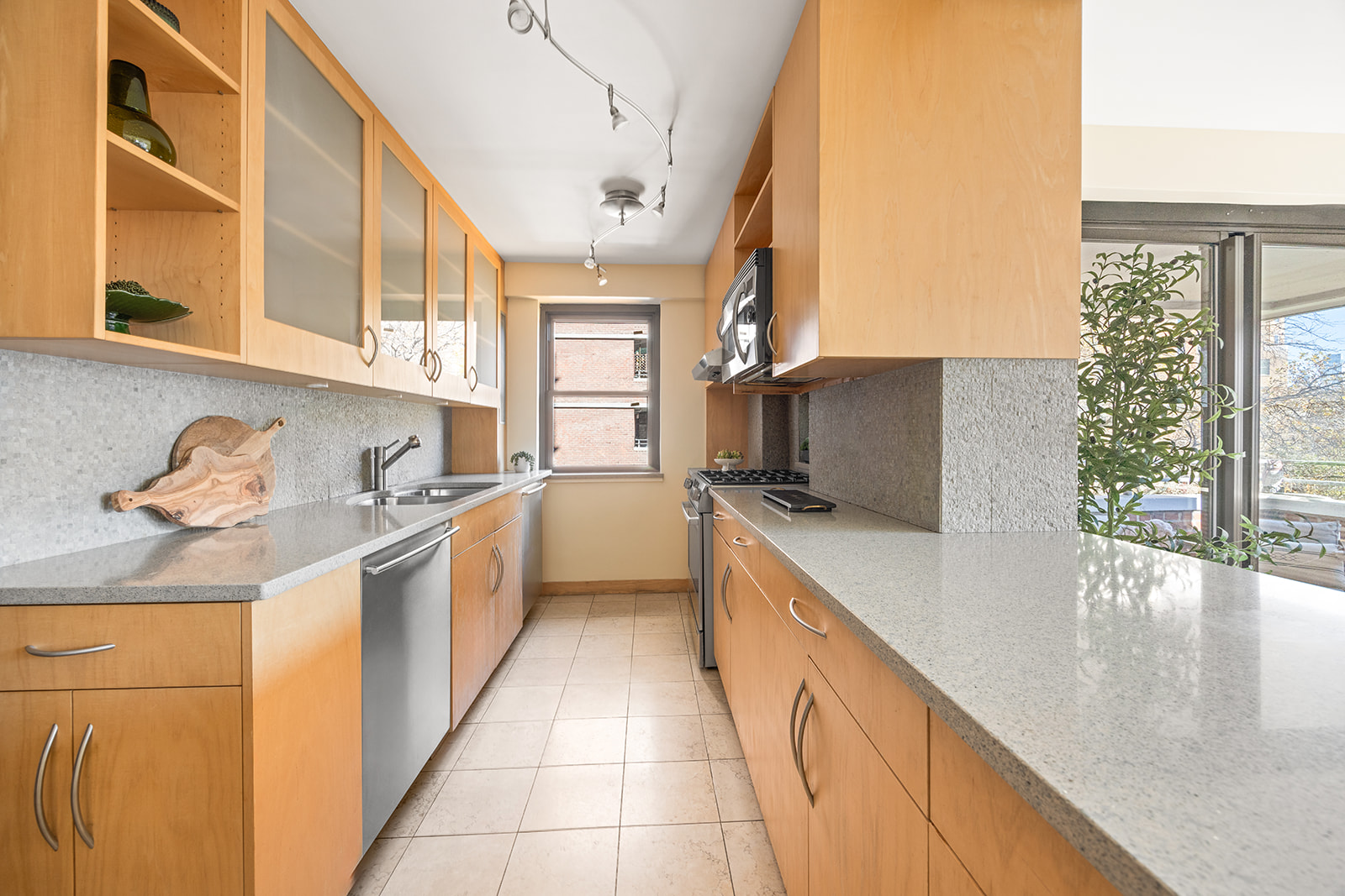 208 East Broadway, Unit J405/J406 Manhattan, NY 10002 - Photo 4 of 21 a kitchen with stainless steel appliances granite countertop a sink and a stove
