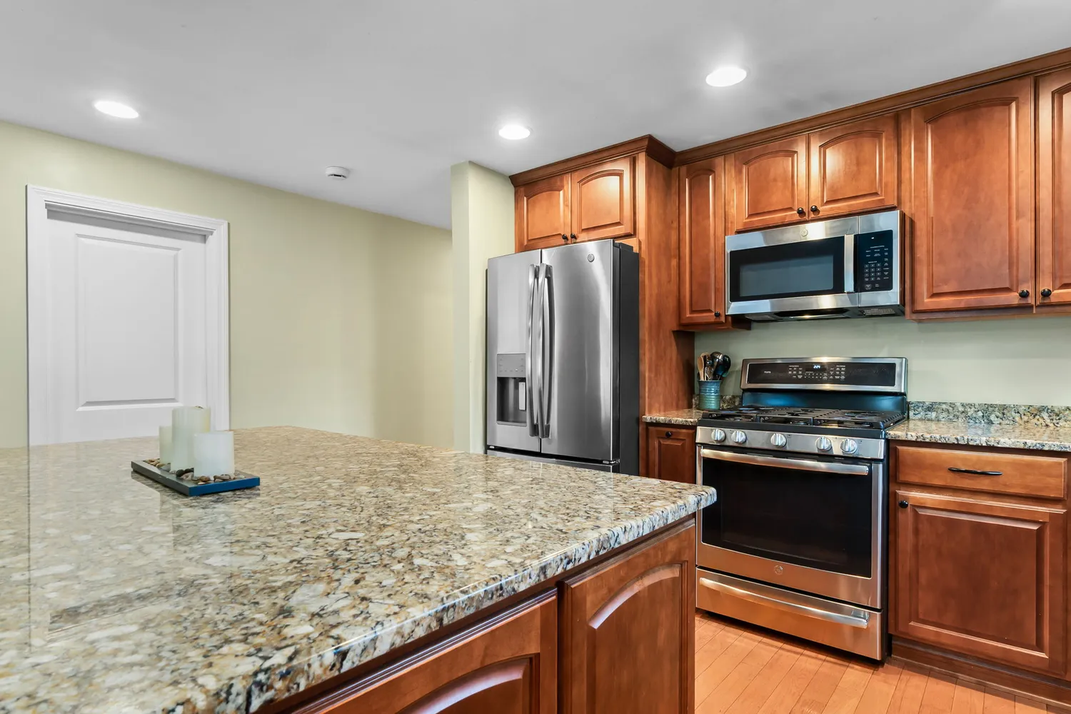 a kitchen with stainless steel appliances granite countertop a stove microwave and refrigerator