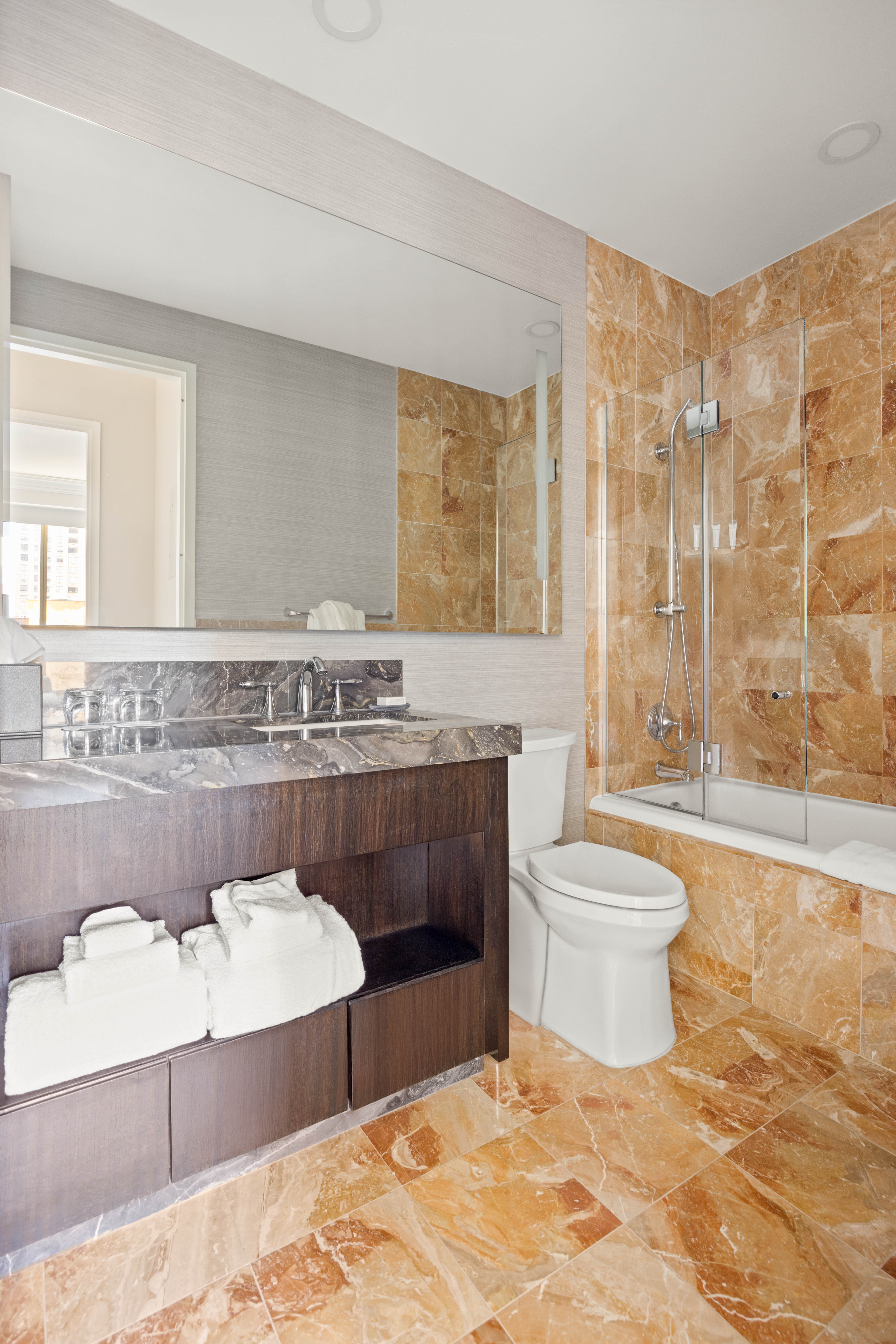 1 Central Park West, Unit 1218 Manhattan, NY 10023 - Photo 5 of 11 a bathroom with a granite countertop bathtub sink vanity mirror and toilet