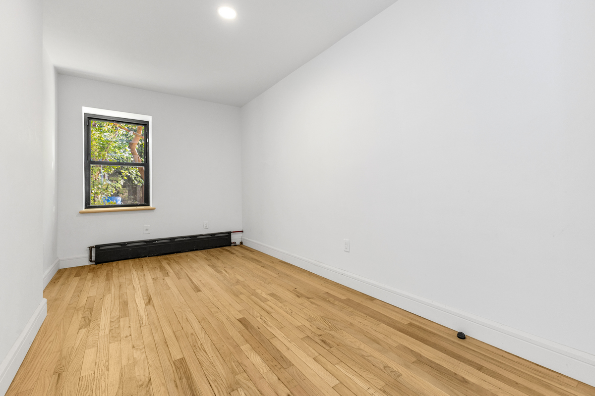 574 Gates Avenue Brooklyn, NY 11221 - Photo 13 of 16 a view of a room with wooden floor and window