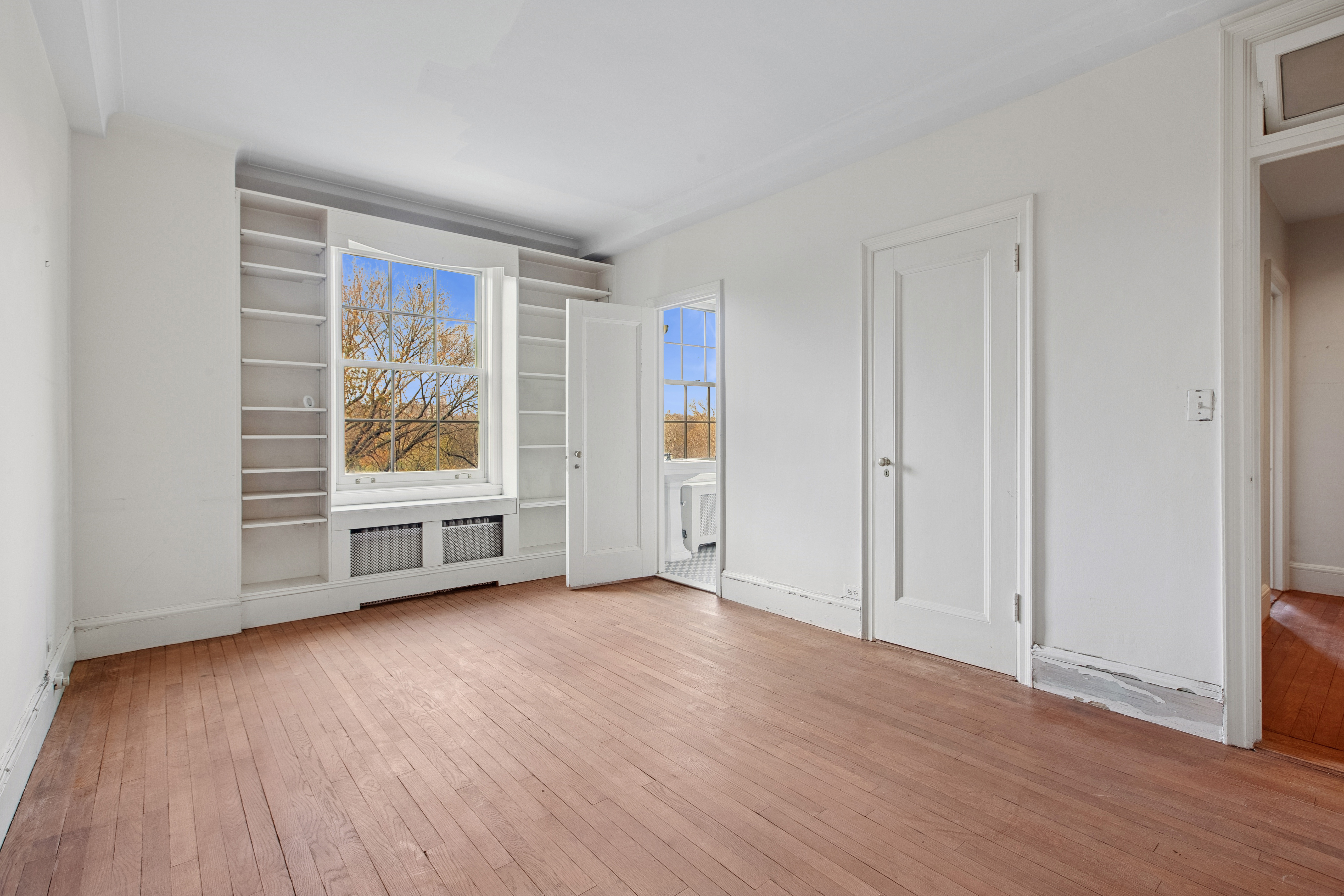 1170 5th Avenue, Unit 6A Manhattan, NY 10029 - Photo 10 of 17 an empty room with wooden floor and window