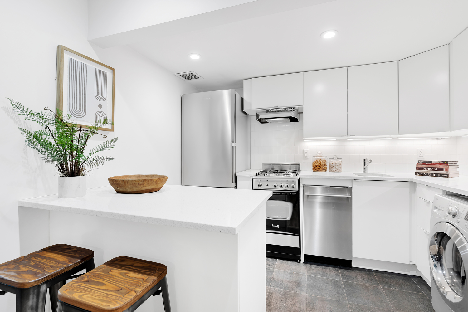 118 Suffolk Street, Unit 3A Manhattan, NY 10002 - Photo 2 of 8 a kitchen with stainless steel appliances a refrigerator a sink a stove and white cabinets