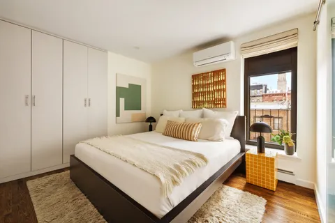 a large bedroom with a bed and wooden floor